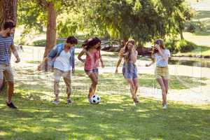 Happy friends in the park with football