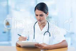 Beautiful doctor holding clipboard with file