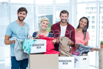 Smiling young friends volunteers separating clothes