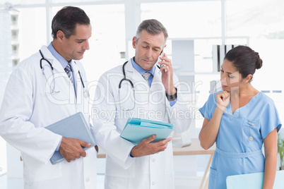 Doctor having phone call while his colleague speaking