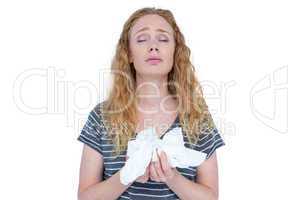 Sick blonde woman holding paper tissue
