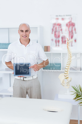 Smiling doctor showing laptop pc