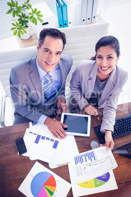 Smiling business team working in digital tablet