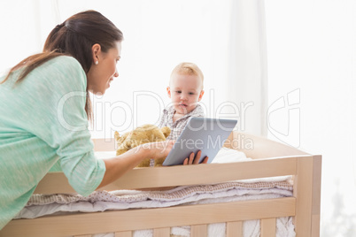 Happy mother using tablet with his baby boy