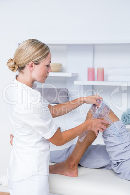 Doctor examining man leg with tool