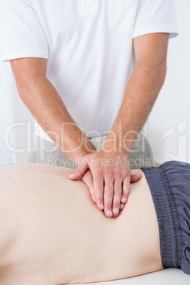 Physiotherapist doing back massage to his patient
