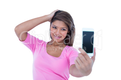 Pretty brunette taking a selfie with smartphone