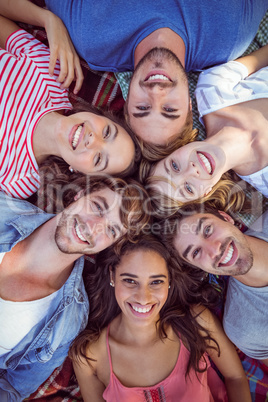 happy friends in a park huddling in circle