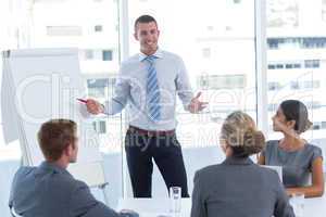 Manager presenting whiteboard to his colleagues