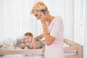 Smiling blonde woman with his son phoning