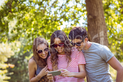 friends looking photos in a park
