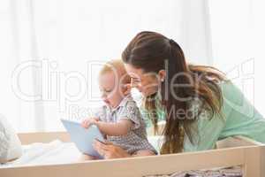 Happy mother using tablet with his baby boy