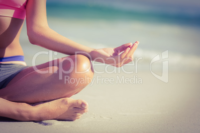 Close up view of fit woman doing yoga beside the sea