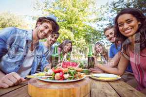 Happy friends in the park having picnic