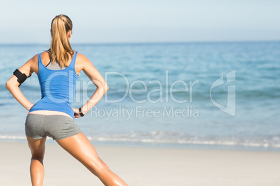 Wear view of fit woman stretching her leg