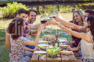 Happy friends in the park having lunch