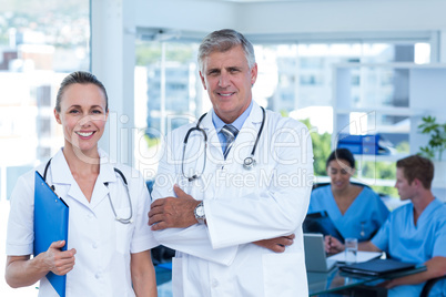 Team of doctors standing arms crossed and smiling at camera