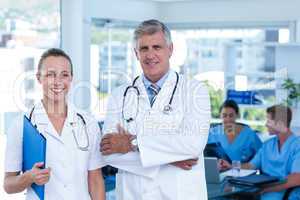 Team of doctors standing arms crossed and smiling at camera