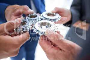 Business colleagues holding cog