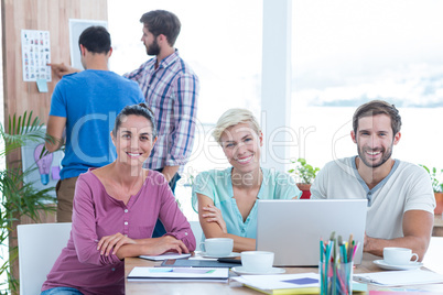 Creative colleagues using laptop in meeting