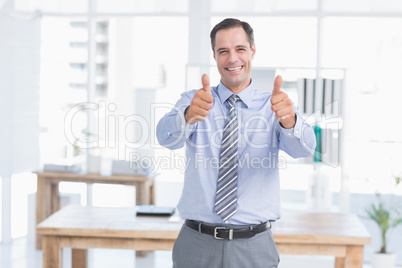 Businessman smiling at camera with thumbs up