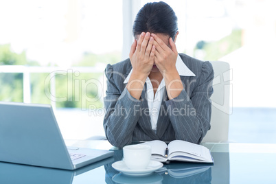 Worried businessman with head in hands