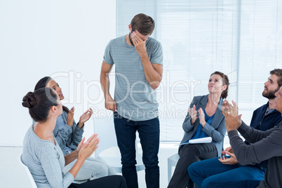 Rehab group applauding delighted man standing up