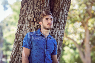 Handsome thinking hipster in the park