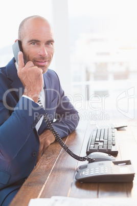 Businessman looking at camera and calling