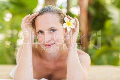 Peaceful blonde lying on towel with candle
