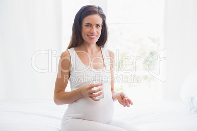 Smiling pregnancy taking a vitamin