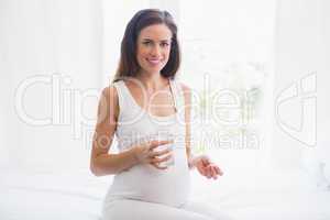 Smiling pregnancy taking a vitamin