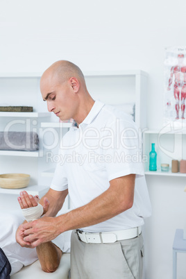 Doctor bandaging his patient hand