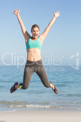 Beautiful fit woman cheering in front of sea