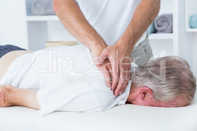 Physiotherapist doing shoulder massage to his patient