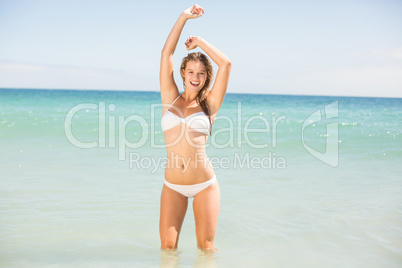 Happy pretty blonde looking at camera into the sea