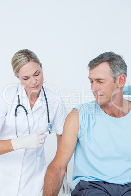 Doctor doing an injection to her patient