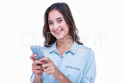 Pretty hipster smiling at camera and using smartphone