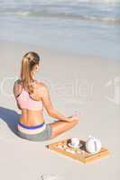 Fit woman doing yoga beside the sea