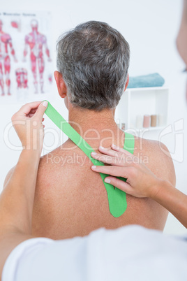 Doctor examining her patient shoulder