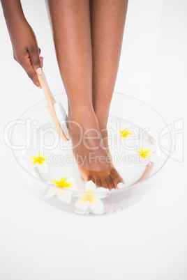 Woman rubbing her foot with pumice
