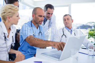 Doctor showing laptop pc to his colleagues