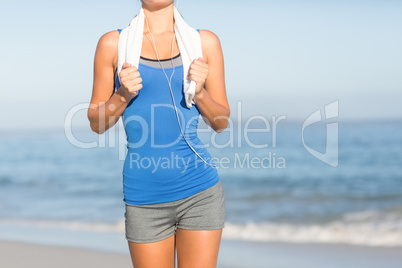 Fit woman running with towel around neck