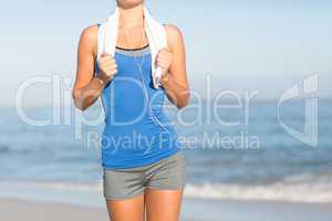 Fit woman running with towel around neck