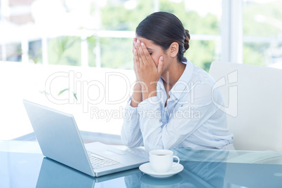 Worried businessman with head in hands