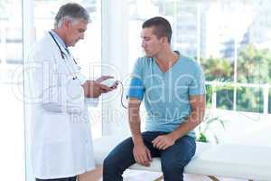 Doctor examining his patients blood pressure