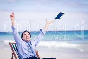 Carefree businessman throwing up his tablet in the air