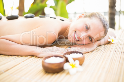 Beautiful woman receiving stone massage at spa center