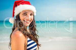 Pretty brunette in santa hat looking at camera