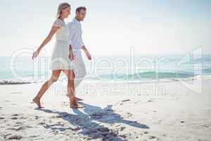 Couple holding hands and standing at beach